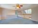 A spacious loft area is illuminated by a ceiling fan and natural light from a nearby window at 502 Brookline Pl, Mcdonough, GA 30252