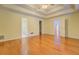 Spacious primary bedroom featuring tray ceilings, hardwood floors, and ensuite bathroom access at 502 Brookline Pl, Mcdonough, GA 30252
