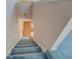 View down the carpeted staircase with painted walls and wood railing at 502 Brookline Pl, Mcdonough, GA 30252