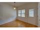 Versatile room with hardwood floors, featuring a vintage light fixture and access to the outdoors at 1453 Cambridge Cmn, Decatur, GA 30033