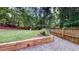 A fenced backyard with mature trees provides privacy and plenty of space for play and gardening at 203 Cedar Creek Ct, Acworth, GA 30101