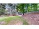 Large backyard with a grassy slope, mature trees, and a wooden privacy fence at 203 Cedar Creek Ct, Acworth, GA 30101