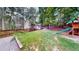 Expansive backyard featuring a wooden playset, lush lawn, and privacy fence at 203 Cedar Creek Ct, Acworth, GA 30101