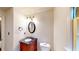 Traditional half bathroom features a decorative vanity with dark countertop, oval mirror and natural light from the window at 203 Cedar Creek Ct, Acworth, GA 30101
