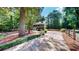Quaint home with a covered porch, surrounded by lush greenery and a long driveway at 203 Cedar Creek Ct, Acworth, GA 30101
