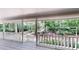 Enjoy the nature views from this outdoor covered porch with white railing and stairs at 203 Cedar Creek Ct, Acworth, GA 30101