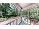 Covered porch features white railings and a peaceful view of surrounding wooded landscape at 203 Cedar Creek Ct, Acworth, GA 30101