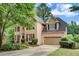 Elegant brick home featuring an attached garage, manicured lawn, and traditional design elements at 615 Willowbrook Run, Johns Creek, GA 30022