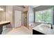 Bright bathroom featuring a soaking tub, separate shower, and vanity area at 615 Willowbrook Run, Johns Creek, GA 30022