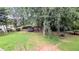 Large backyard featuring lush greenery, mature trees and an in-ground trampoline at 75 Maygold St, Mcdonough, GA 30253