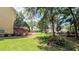 Expansive backyard with lush lawn, mature trees, deck, and a glimpse of a sparkling pool at 75 Maygold St, Mcdonough, GA 30253