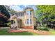 Side view of a yellow two-story house with a bay window and manicured lawn and landscaping at 75 Maygold St, Mcdonough, GA 30253