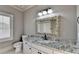 Bathroom with a large mirror, single sink, white cabinets, and granite countertops at 8455 Abingdon Ln, Duluth, GA 30097