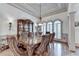 Elegant dining room with a long table, ornate chairs, hardwood floors, and custom cabinetry at 8455 Abingdon Ln, Duluth, GA 30097