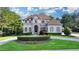 Elegant two-story home with a manicured lawn, circular driveway, and lush landscaping at 8455 Abingdon Ln, Duluth, GA 30097