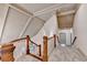 Carpeted hallway with wood railing, white balusters, and high ceilings provides access to upper level living spaces at 8455 Abingdon Ln, Duluth, GA 30097
