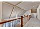 Bright hallway with overhead lighting and railing overlooking foyer with crystal chandelier and arched window at 8455 Abingdon Ln, Duluth, GA 30097
