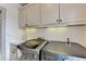 This laundry room has modern machines, a sink, and cabinets for storage at 8455 Abingdon Ln, Duluth, GA 30097