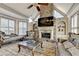 Living room with stone fireplace, vaulted ceilings, large windows, and custom built-in shelving at 8455 Abingdon Ln, Duluth, GA 30097
