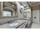 This main bathroom features double sinks, stone countertops, and a large decorative mirror at 8455 Abingdon Ln, Duluth, GA 30097
