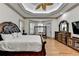 This main bedroom features a tray ceiling, windows, hardwood floors, and classic furniture at 8455 Abingdon Ln, Duluth, GA 30097