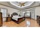 This main bedroom features a tray ceiling, windows, hardwood floors, and classic furniture at 8455 Abingdon Ln, Duluth, GA 30097