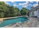 Inviting pool with stone surround and outdoor kitchen, perfect for entertaining in a private, lush setting at 8455 Abingdon Ln, Duluth, GA 30097