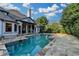 Beautiful backyard swimming pool with stone patio and covered outdoor seating area at 8455 Abingdon Ln, Duluth, GA 30097