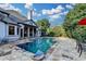 Beautiful backyard swimming pool with stone patio and covered outdoor seating area at 8455 Abingdon Ln, Duluth, GA 30097
