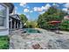 Beautiful outdoor dining area with a stone patio next to a pool and landscaped backyard at 8455 Abingdon Ln, Duluth, GA 30097