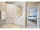 Bathroom showcasing white cabinetry, marble floors, and access to the main bedroom at 1111 Waterford Green Pt, Marietta, GA 30068