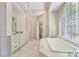 Luxurious bathroom boasting marble floors, custom cabinetry, a soaking tub, and a separate glass shower at 1111 Waterford Green Pt, Marietta, GA 30068