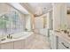 Elegant bathroom with a large window over the soaking tub, chandelier, and marble floors at 1111 Waterford Green Pt, Marietta, GA 30068