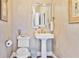 Chic powder room with pedestal sink, decorative mirror and elegant gold fixtures at 1111 Waterford Green Pt, Marietta, GA 30068