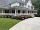 Charming home showcasing a large wraparound porch, black shutters, and fresh landscaping at 125 Sir Lancelot Ct, Fayetteville, GA 30214
