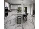 Well-appointed kitchen with white cabinetry, stainless appliances, island with seating, and marble floors at 125 Sir Lancelot Ct, Fayetteville, GA 30214