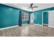 Bright bedroom with teal walls, modern ceiling fan, and ample sunlight at 3860 Paint Cir, Douglasville, GA 30135