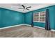 Vibrant bedroom with teal walls, wood-look floors, and ample natural light at 3860 Paint Cir, Douglasville, GA 30135
