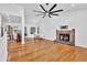 Spacious living room featuring hardwood floors, a stone fireplace, high ceilings, and a modern ceiling fan at 3860 Paint Cir, Douglasville, GA 30135