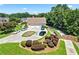 Gorgeous home with a three-car garage, lush landscaping, and a circular driveway nestled in trees at 2012 Arbor Springs Way, Buford, GA 30519