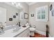 Neutral-toned half-bathroom with window, vanity, framed mirror, and wood flooring at 2012 Arbor Springs Way, Buford, GA 30519