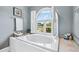 Bright bathroom featuring a soaking tub with view, and white shutters at 2012 Arbor Springs Way, Buford, GA 30519