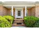 Elegant brick home entrance featuring decorative columns and arched windows flanking the front door at 2012 Arbor Springs Way, Buford, GA 30519
