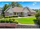 Charming brick home featuring a lush front lawn with manicured shrubbery and classic architectural design at 2012 Arbor Springs Way, Buford, GA 30519