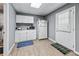 Basement kitchenette with white cabinets, sink, microwave, fridge, and a door to outside at 2012 Arbor Springs Way, Buford, GA 30519