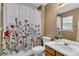 Bathroom with a floral shower curtain, toilet, sink, mirror and wooden cabinets at 303 Fox Overlook, Woodstock, GA 30188