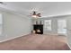 Cozy living room featuring a fireplace, ceiling fan, and natural light at 303 Fox Overlook, Woodstock, GA 30188