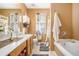 Well-lit bathroom featuring a soaking tub, a vanity with double sinks, and neutral decor at 3198 Liberty Commons Dr, Kennesaw, GA 30144