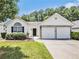 Charming single Gathering home boasts a two car garage, neutral paint, and manicured lawn at 3198 Liberty Commons Dr, Kennesaw, GA 30144