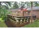 View of a wooden deck shaded by triangular sail with a grill, perfect for outdoor entertaining at 4852 Pine Shadows Dr, Stone Mountain, GA 30088